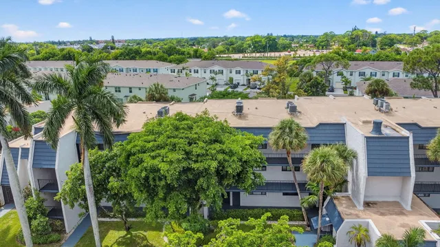 an aerial view of a city with lots of residential buildings ocean and mountain view in back