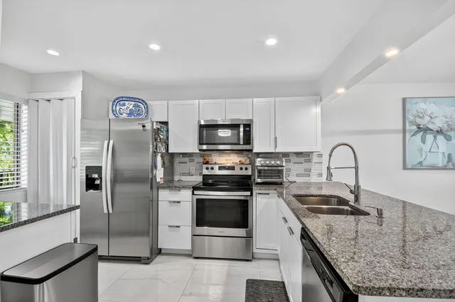 a kitchen with stainless steel appliances a stove microwave and refrigerator