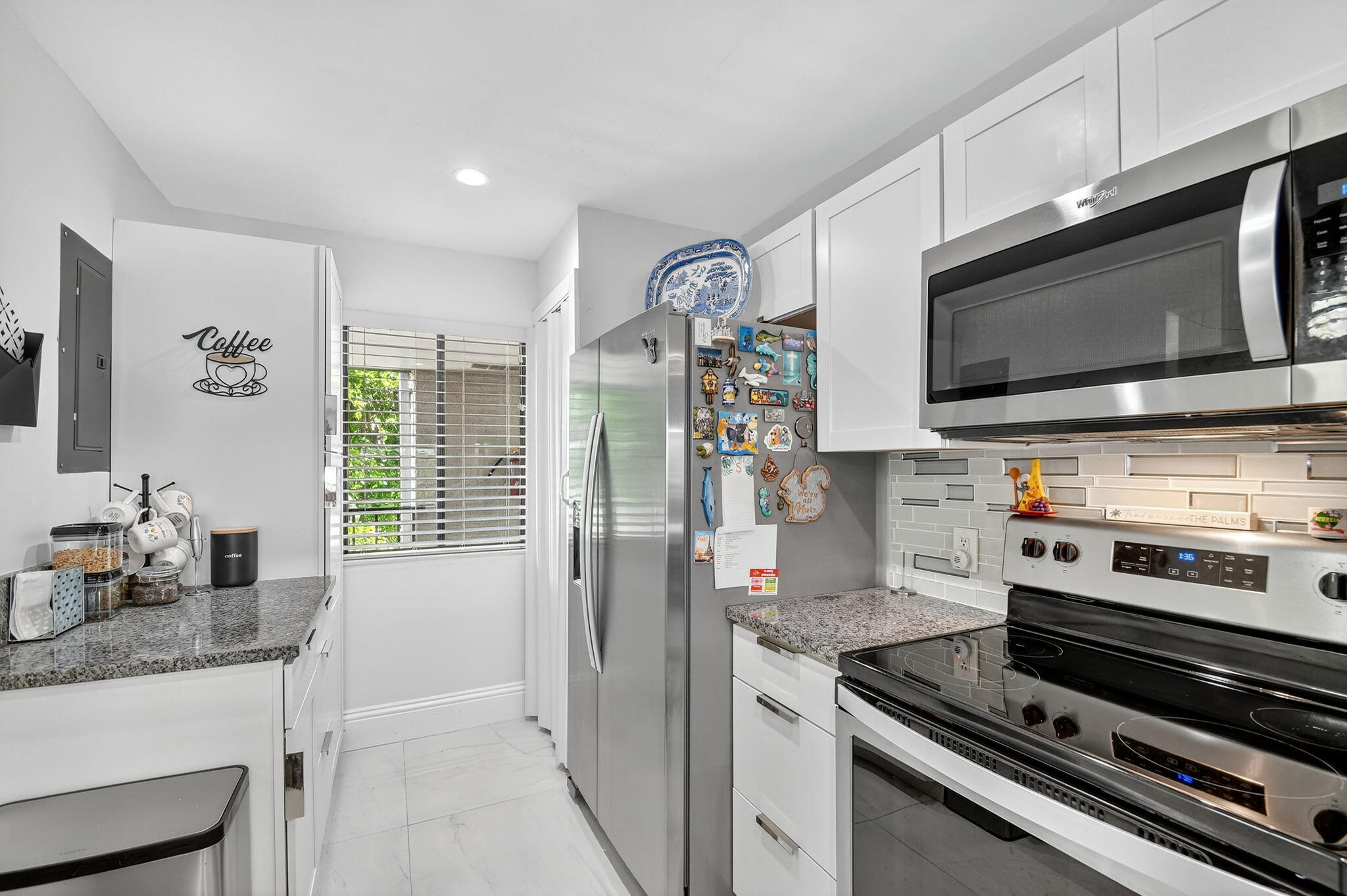 4381 Trevi Court, Unit 303 Lake Worth, FL 33467 - Photo 7 of 80 a kitchen with stainless steel appliances a stove microwave and refrigerator