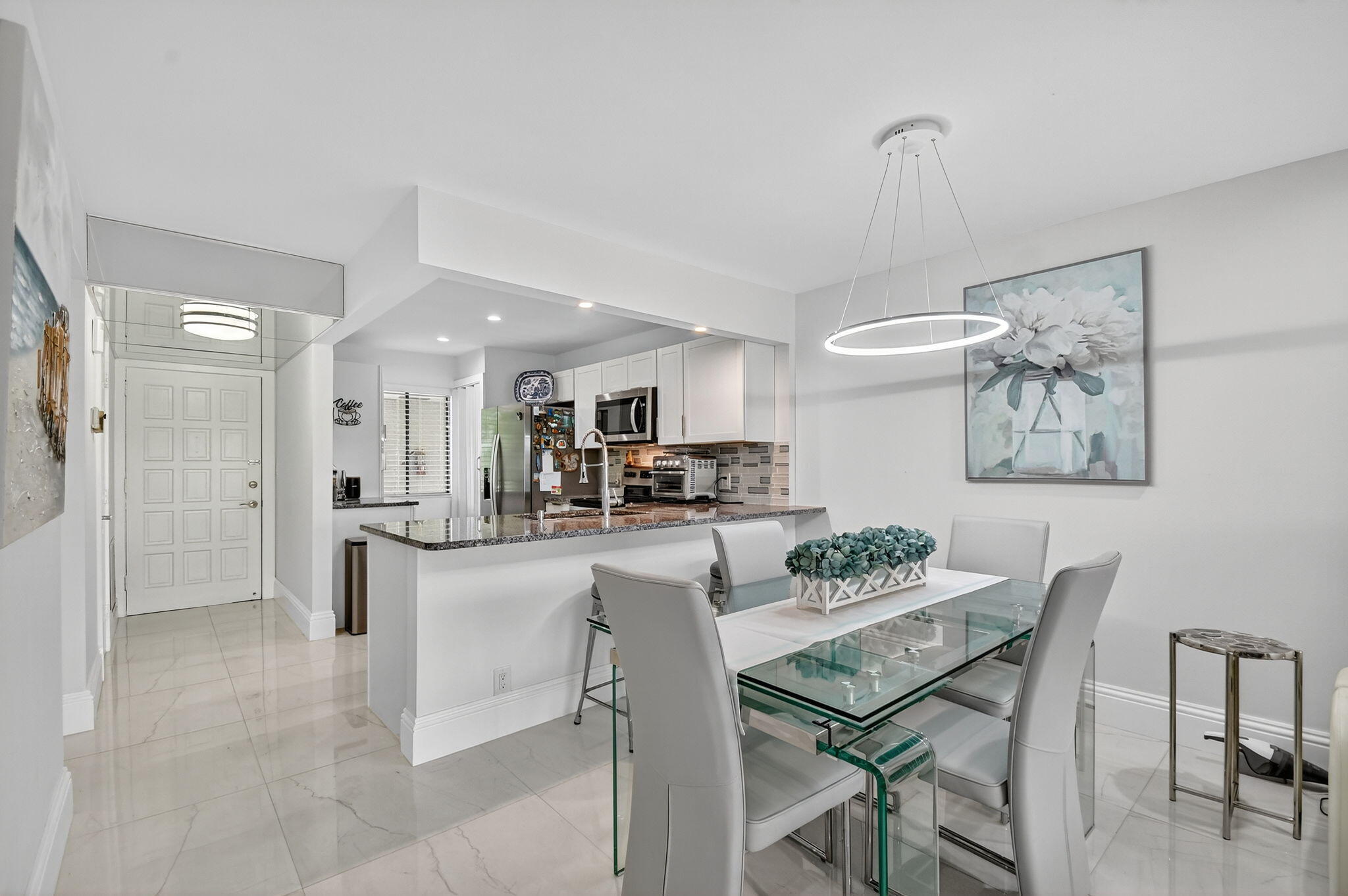 4381 Trevi Court, Unit 303 Lake Worth, FL 33467 - Photo 10 of 80 a kitchen with stainless steel appliances kitchen island granite countertop a refrigerator and a dining table