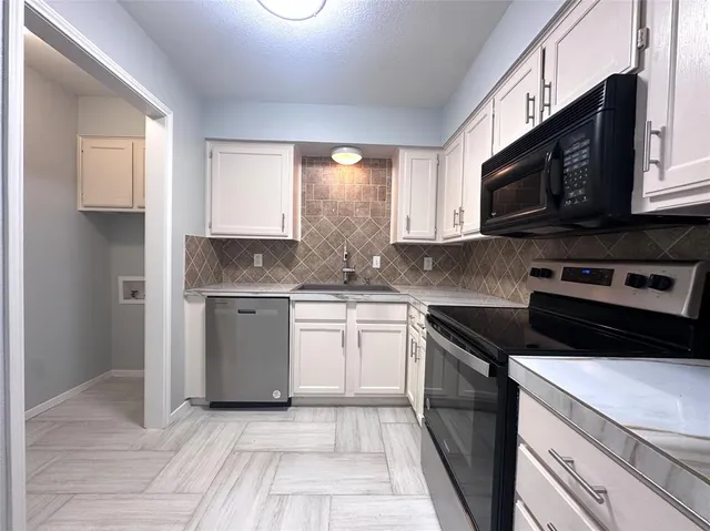 a kitchen with stainless steel appliances granite countertop a sink a stove a microwave and cabinets