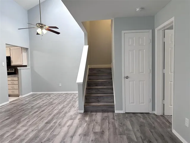 a view of a livingroom with wooden floor and staircase