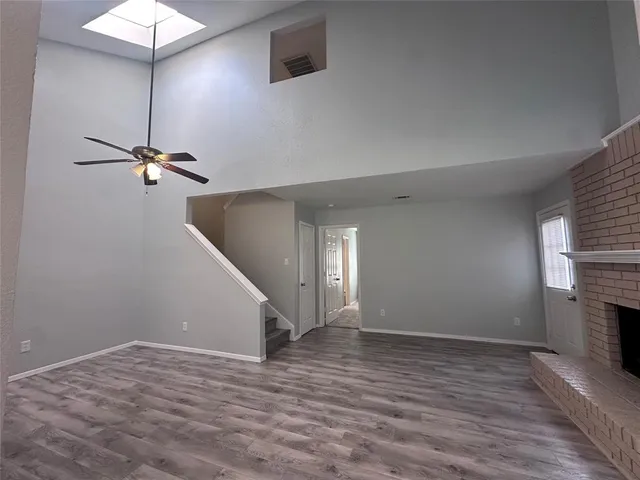 a view of a room with wooden floor and a ceiling fan