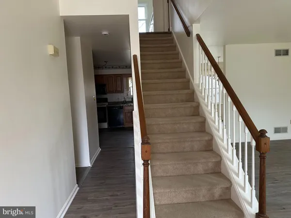 a view of a hallway with wooden floor and entryway