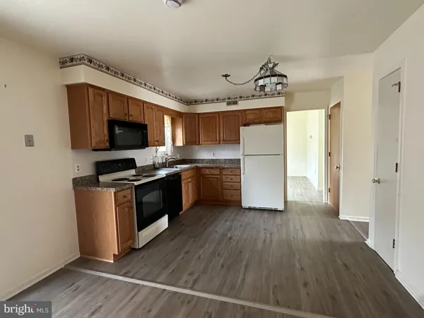 a kitchen with a refrigerator a stove top oven a sink and dishwasher with wooden floor