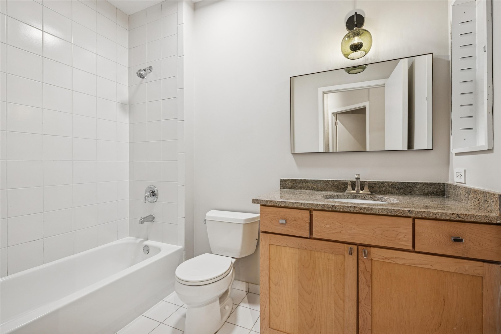 720 North Larrabee Street, Unit 1002 Chicago, IL 60654 - Photo 11 of 20 a bathroom with a granite countertop toilet sink and mirror