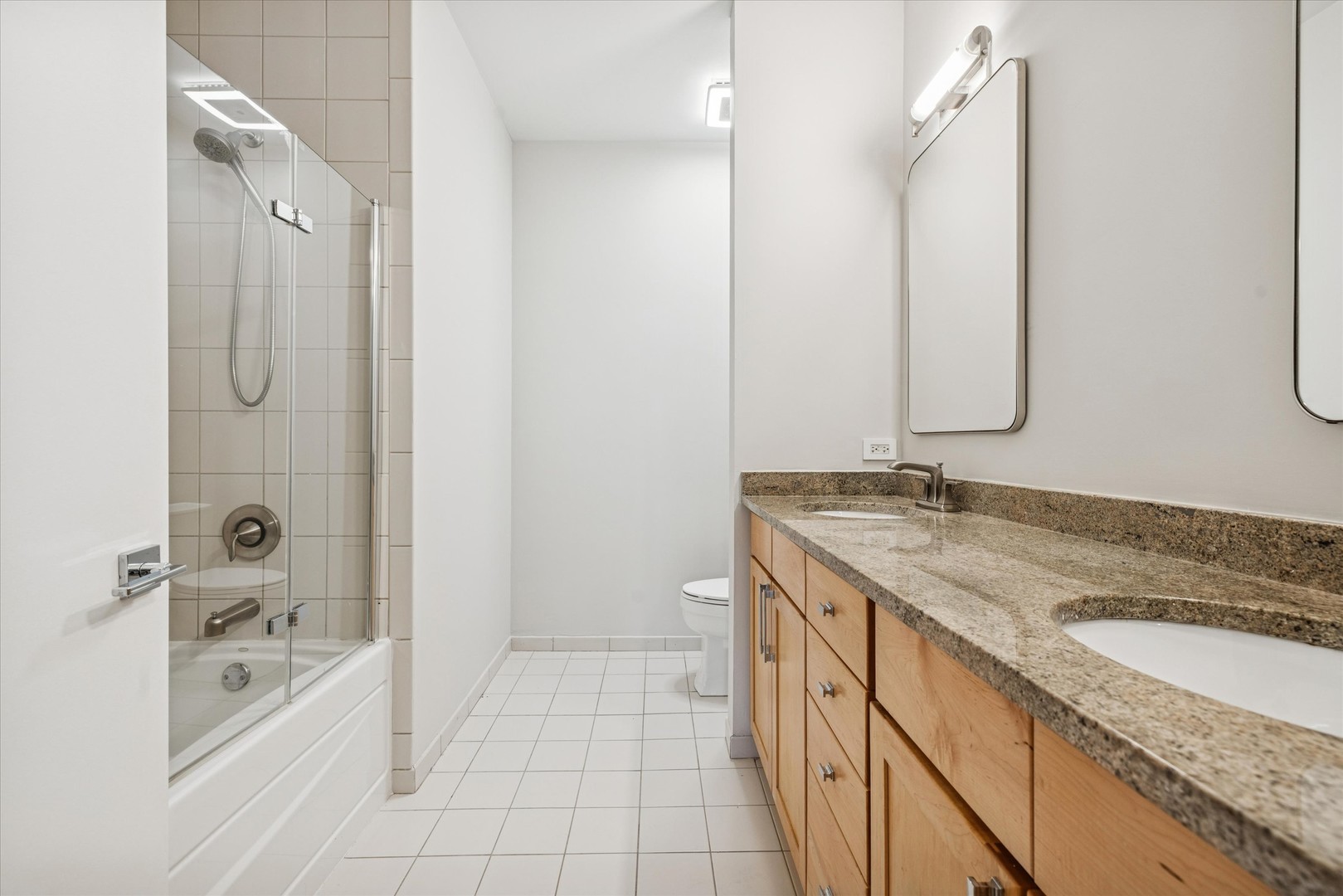 720 North Larrabee Street, Unit 1002 Chicago, IL 60654 - Photo 17 of 20 a bathroom with a granite countertop sink mirror and shower