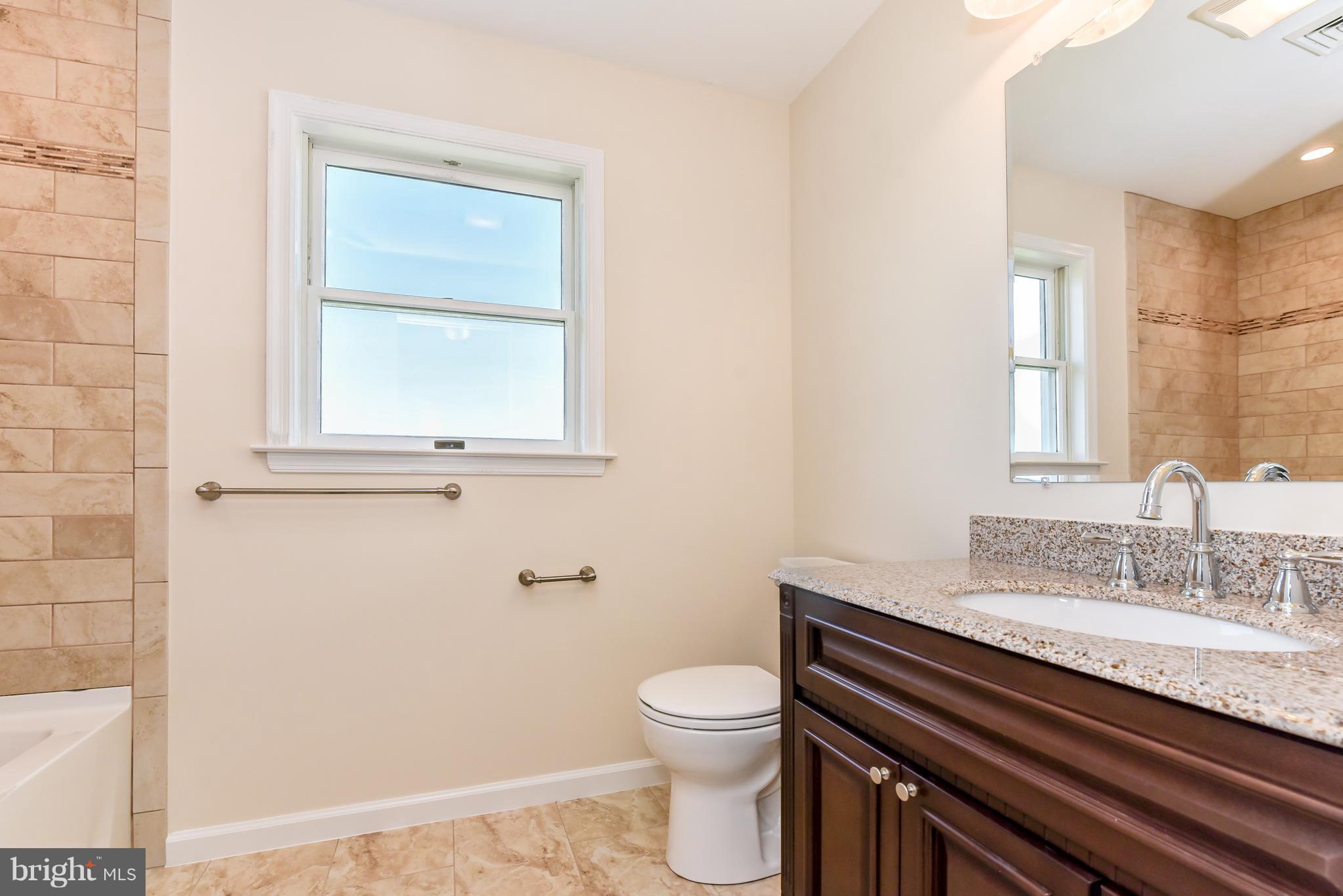 1101 Lombard Road Rising Sun, MD 21911 - Photo 15 of 26 a bathroom with a granite countertop toilet sink and mirror