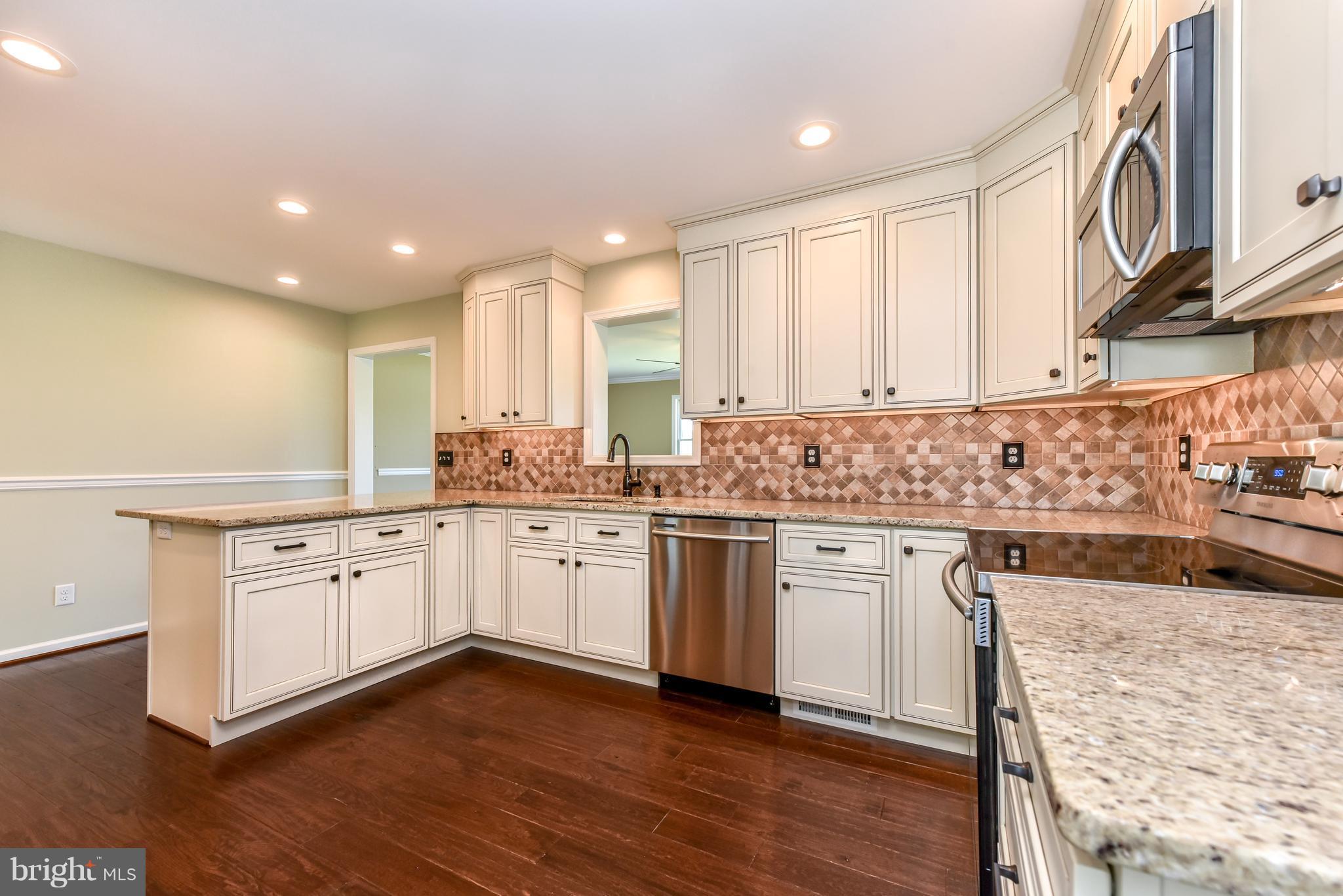 1101 Lombard Road Rising Sun, MD 21911 - Photo 4 of 26 a kitchen with granite countertop white cabinets and white appliances