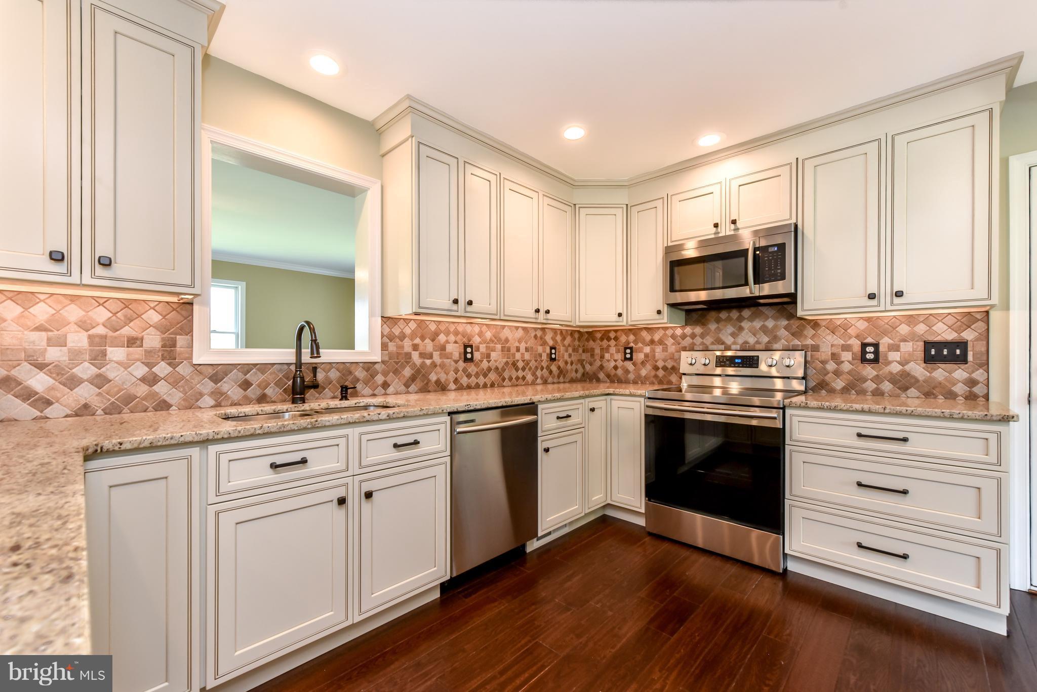 1101 Lombard Road Rising Sun, MD 21911 - Photo 6 of 26 a kitchen with granite countertop white cabinets and white appliances
