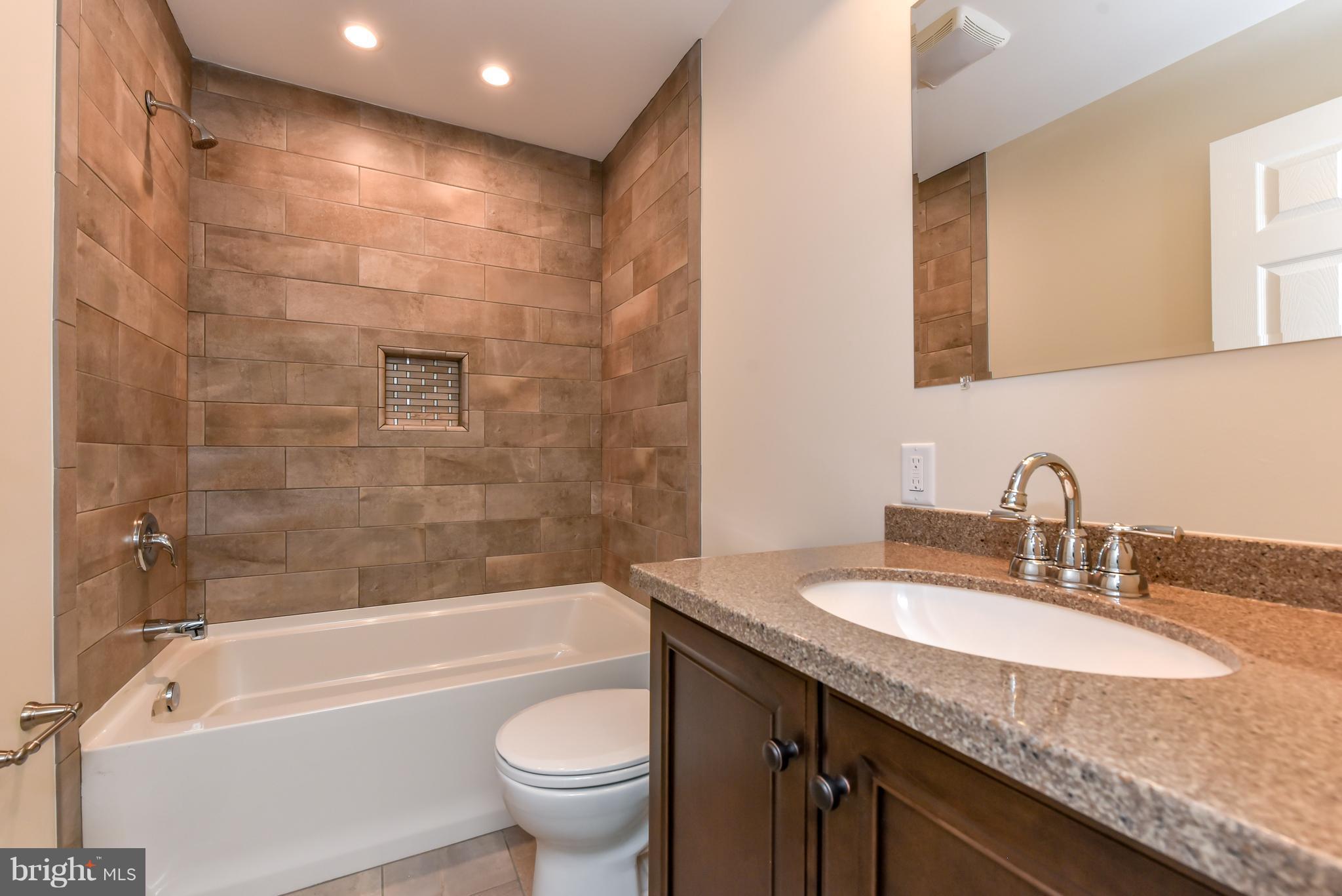 1101 Lombard Road Rising Sun, MD 21911 - Photo 10 of 26 a bathroom with a granite countertop sink a toilet and bathtub