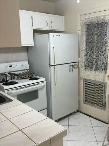 a white refrigerator freezer and a stove sitting inside of a kitchen