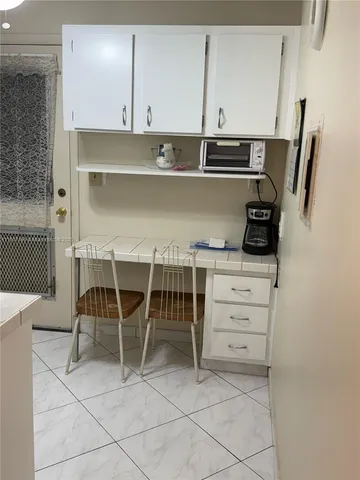 a kitchen with a chair and cabinets