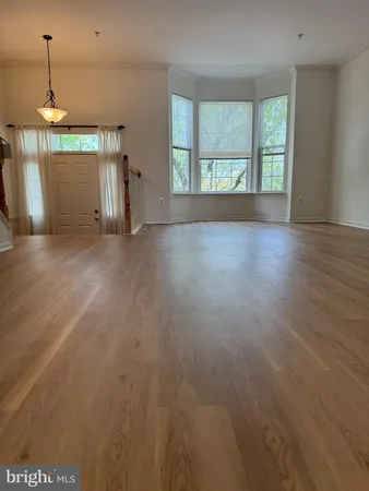 a view of a room with wooden floor and windows