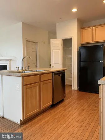 a kitchen with kitchen island granite countertop a sink cabinets and stainless steel appliances