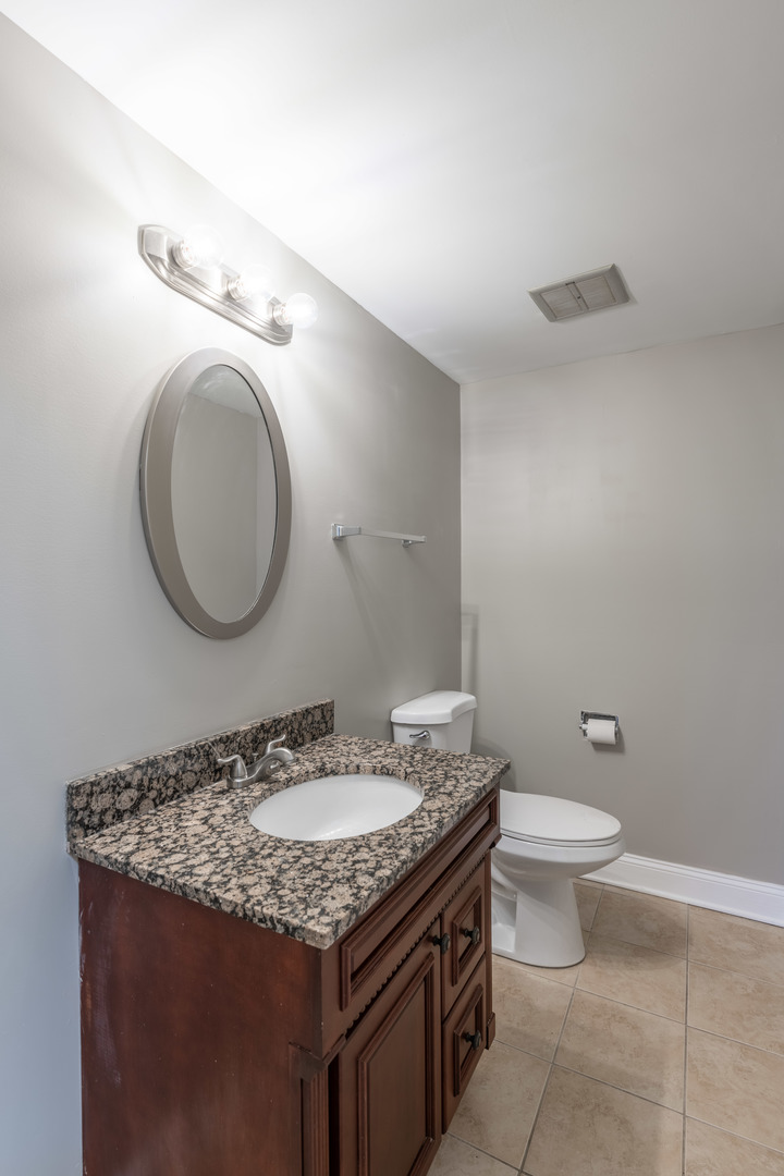 118 East Bailey Road, Unit A Naperville, IL 60565 - Photo 8 of 15 a bathroom with a granite countertop toilet a sink and a mirror