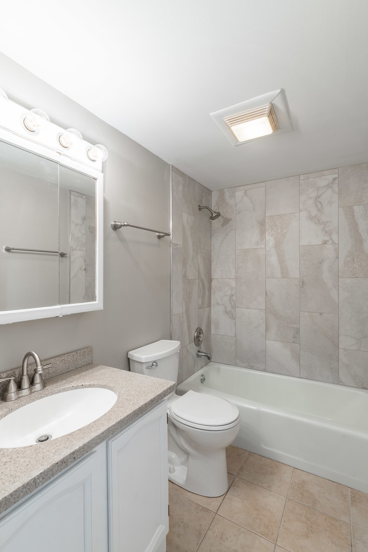 118 East Bailey Road, Unit A Naperville, IL 60565 - Photo 10 of 15 a bathroom with a granite countertop sink a toilet and shower