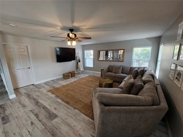 a living room with furniture a ceiling fan and a window