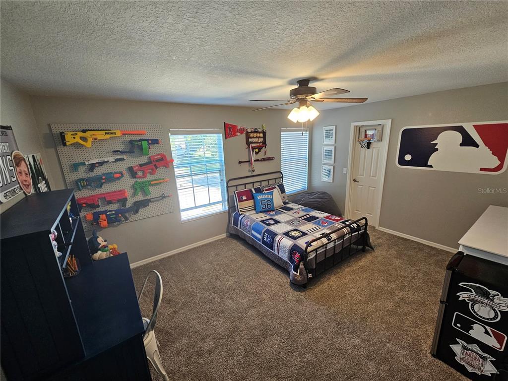 20946 Sullivan Ranch Boulevard Mount Dora, FL 32757 - Photo 22 of 26 a bedroom with a bed and a chandelier