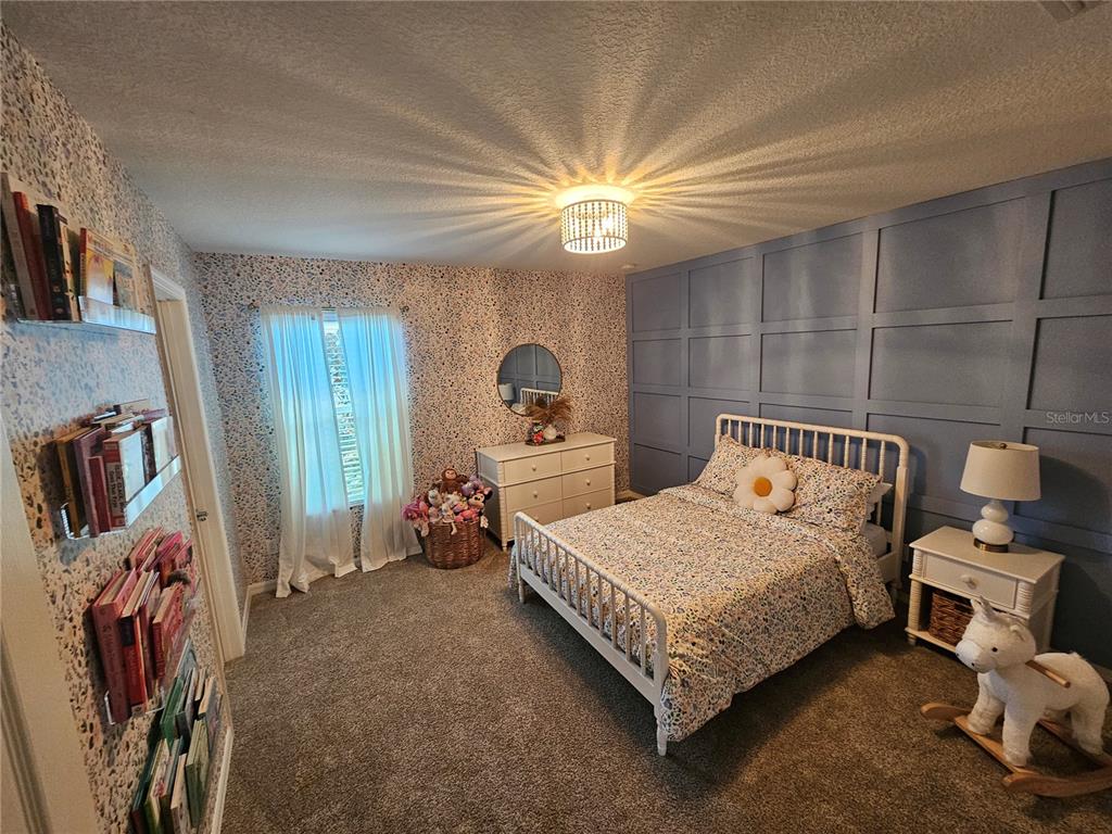 20946 Sullivan Ranch Boulevard Mount Dora, FL 32757 - Photo 24 of 26 a bedroom with a bed and a chandelier