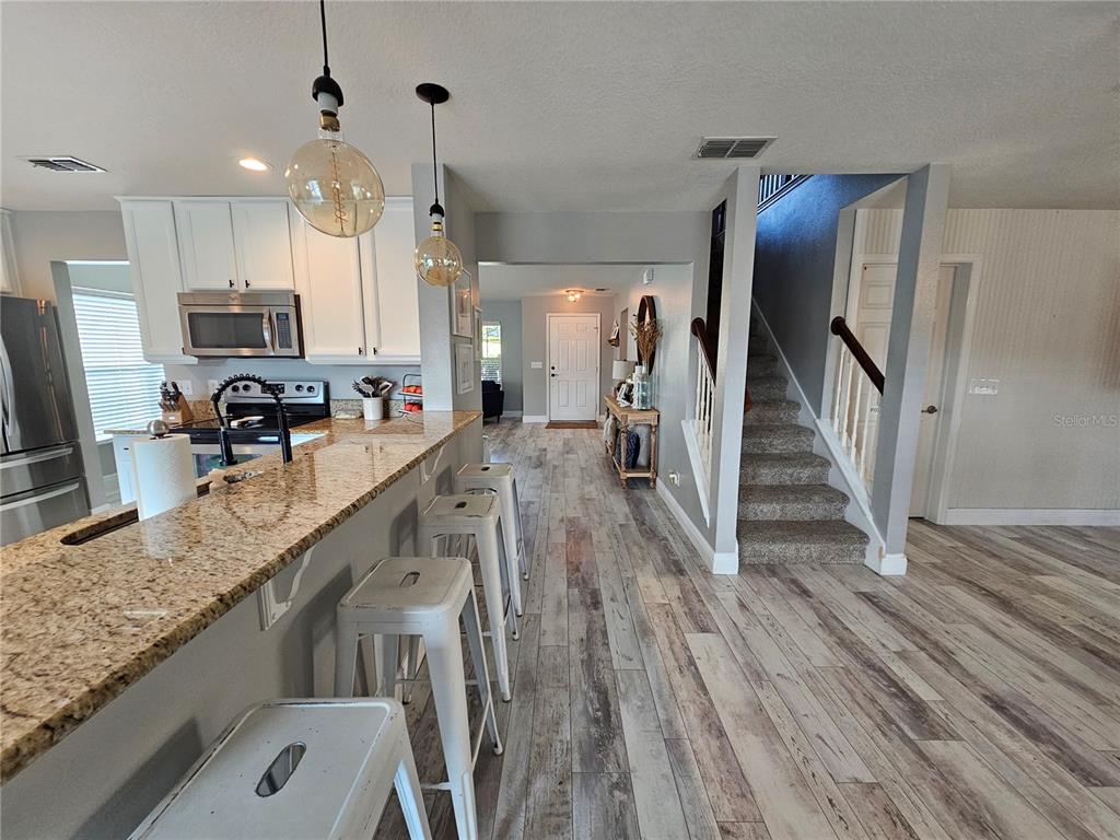20946 Sullivan Ranch Boulevard Mount Dora, FL 32757 - Photo 8 of 26 a kitchen with stainless steel appliances granite countertop a lot of counter space and wooden floors