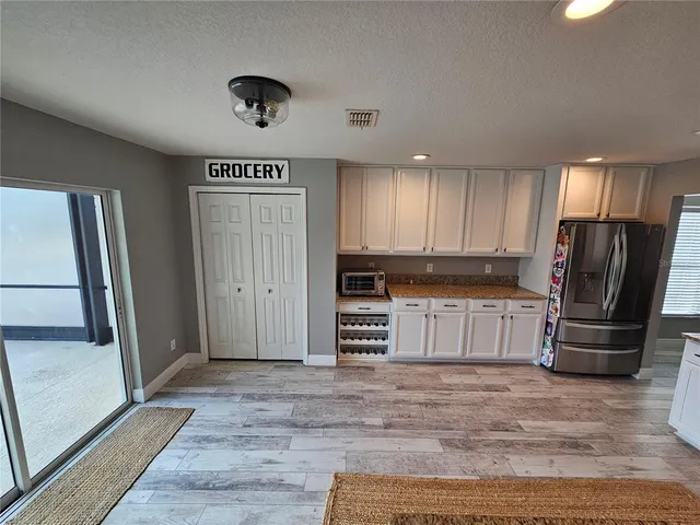 a kitchen with granite countertop a refrigerator and a sink