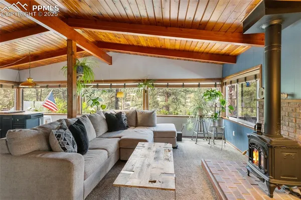 a living room with furniture a large window with kitchen view