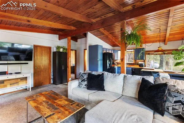 a kitchen with stainless steel appliances kitchen island granite countertop a table chairs in it and a wooden floor