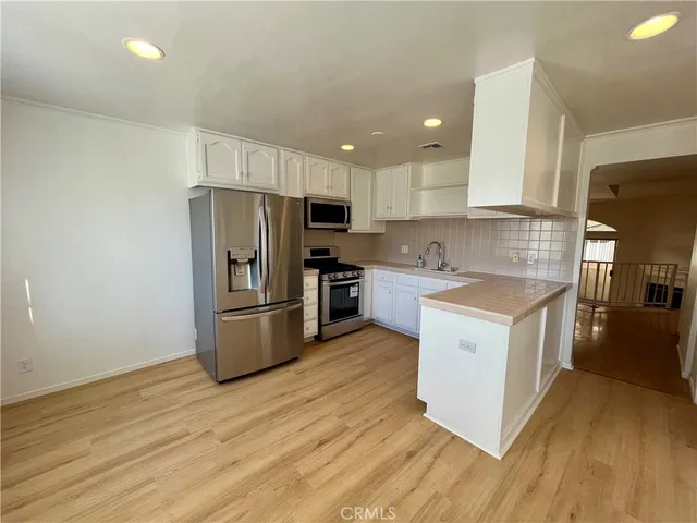 a kitchen with a sink a refrigerator a microwave and cabinets