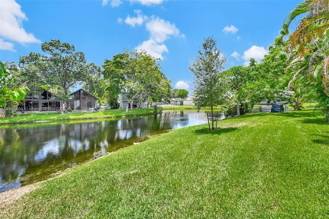 a backyard of a house with lots of green space and fountain