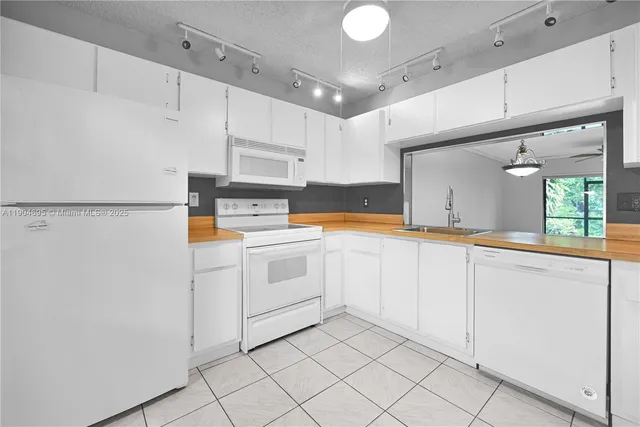 a kitchen with white cabinets and white appliances