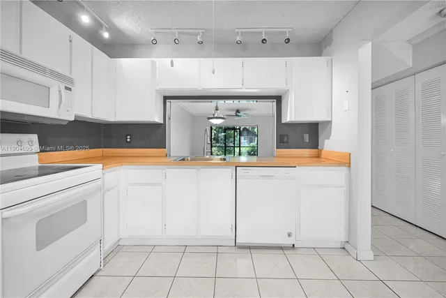a kitchen with white cabinets and white appliances