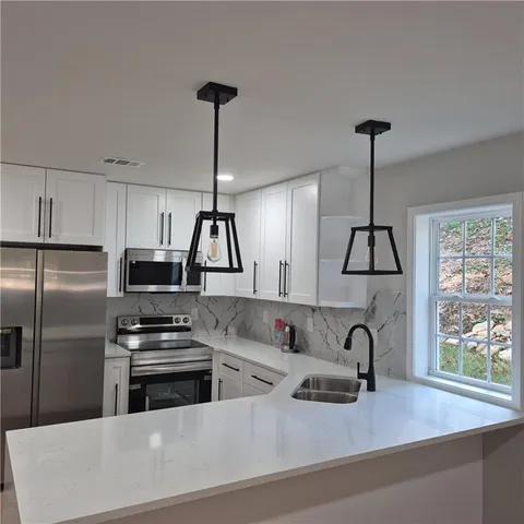 a kitchen with stainless steel appliances a sink a center island and a refrigerator