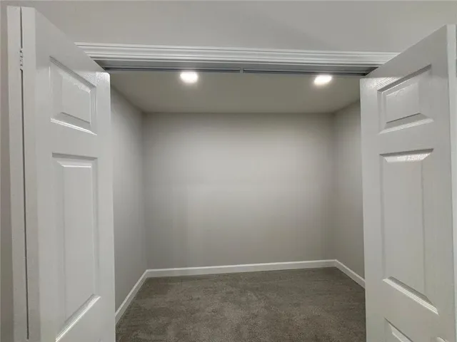 en empty room with windows and ceiling fan