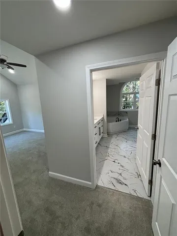 an empty room with ceiling fan and windows