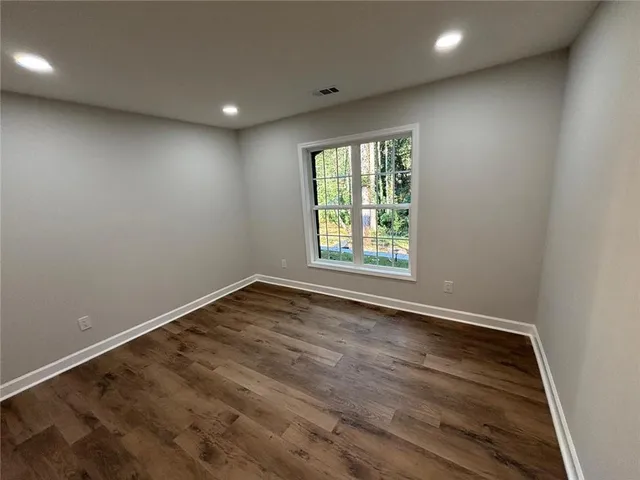 a room with kitchen island a sink and wooden floor