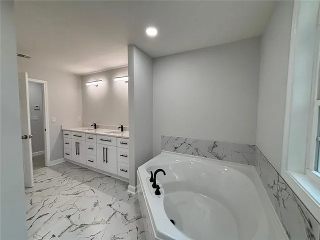 a bathroom with a tub sink and mirror