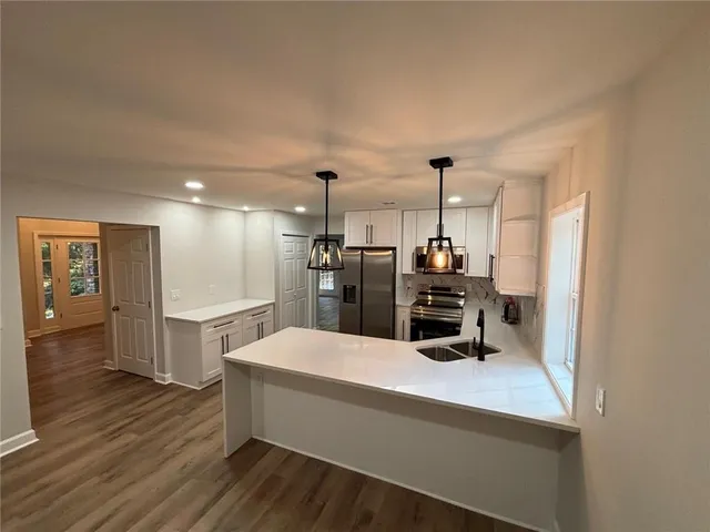 a kitchen with refrigerator and chairs