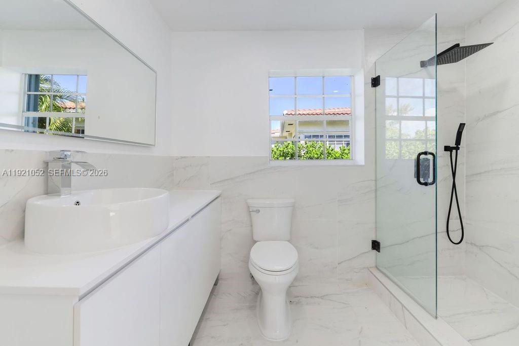 725 91st Street Surfside, FL 33154 - Photo 14 of 32 a bathroom with a toilet sink and shower