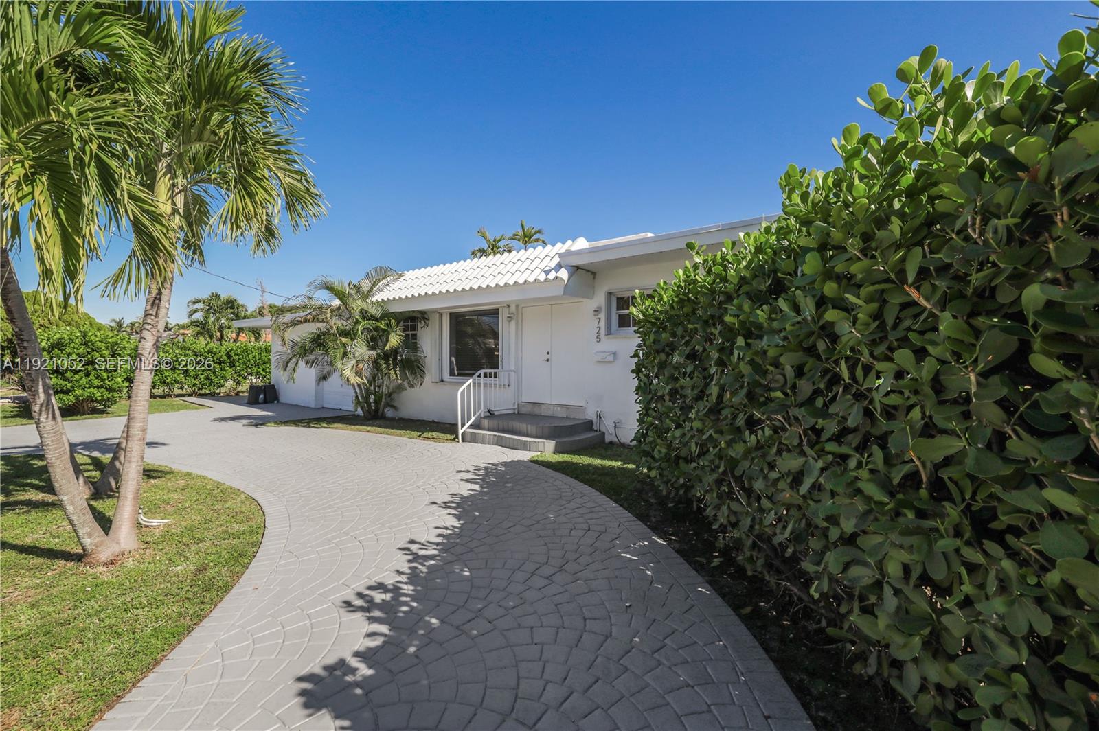725 91st Street Surfside, FL 33154 - Photo 2 of 32 a front view of a house with a yard and a garage
