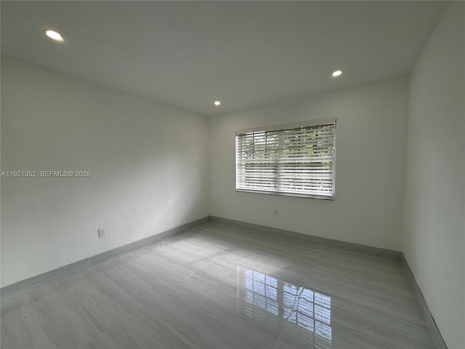 725 91st Street Surfside, FL 33154 - Photo 25 of 32 an empty room with wooden floor and windows