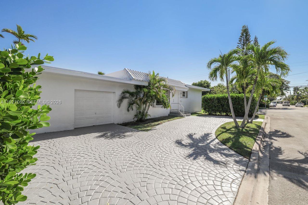 725 91st Street Surfside, FL 33154 - Photo 3 of 32 a plant that is in front of a house