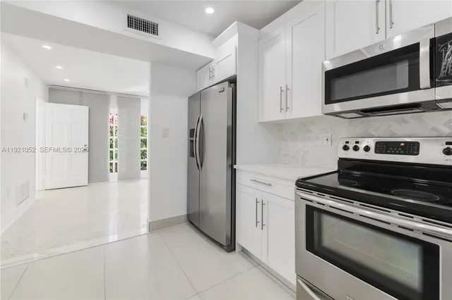 a kitchen with stainless steel appliances granite countertop a refrigerator stove and microwave