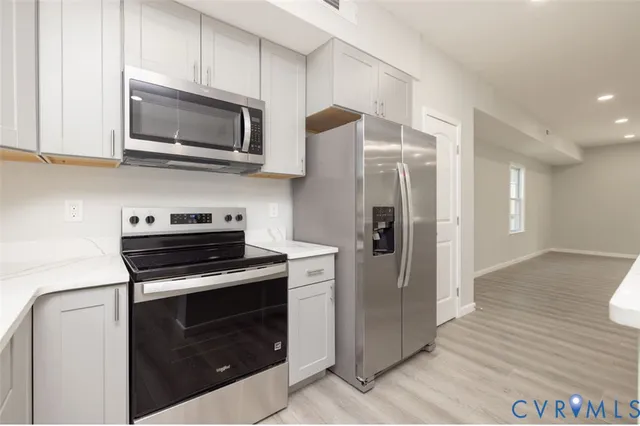 a kitchen with stainless steel appliances a stove a microwave and cabinets