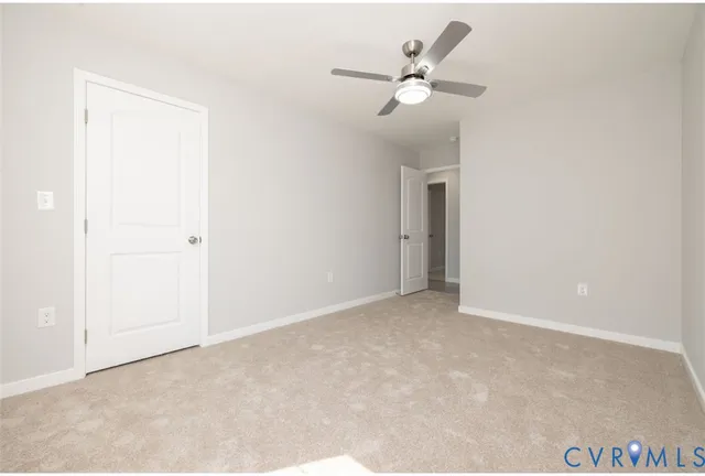 an empty room with a ceiling fan and a window