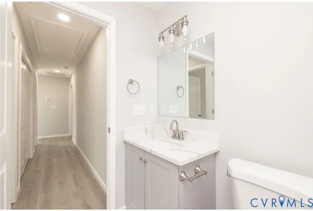 a bathroom with a sink and mirror with toilet