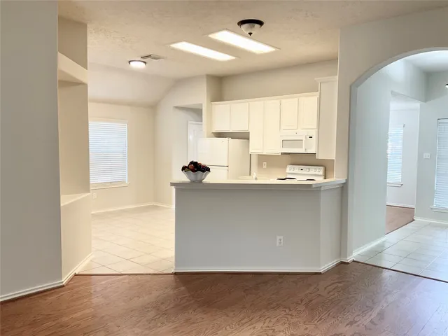 a kitchen with white cabinets and white appliances