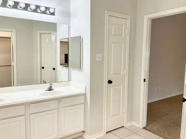 a bathroom with a sink a tub and a mirror