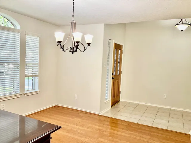 a view of a room with wooden floor and chandelier