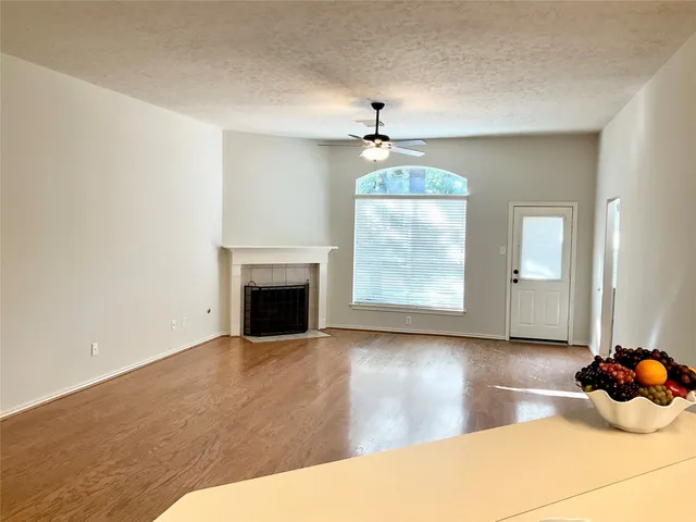a view of a livingroom with wooden floor fireplace and windows